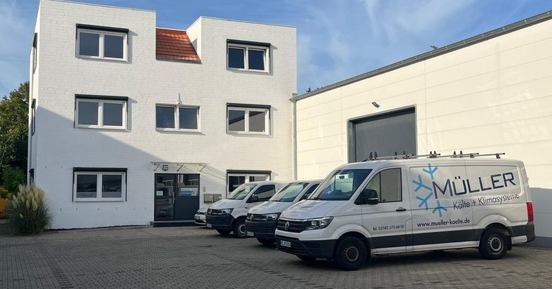 Drei Vans sind vor einem Gebäude abgestellt, das eine einladende Atmosphäre vermittelt.